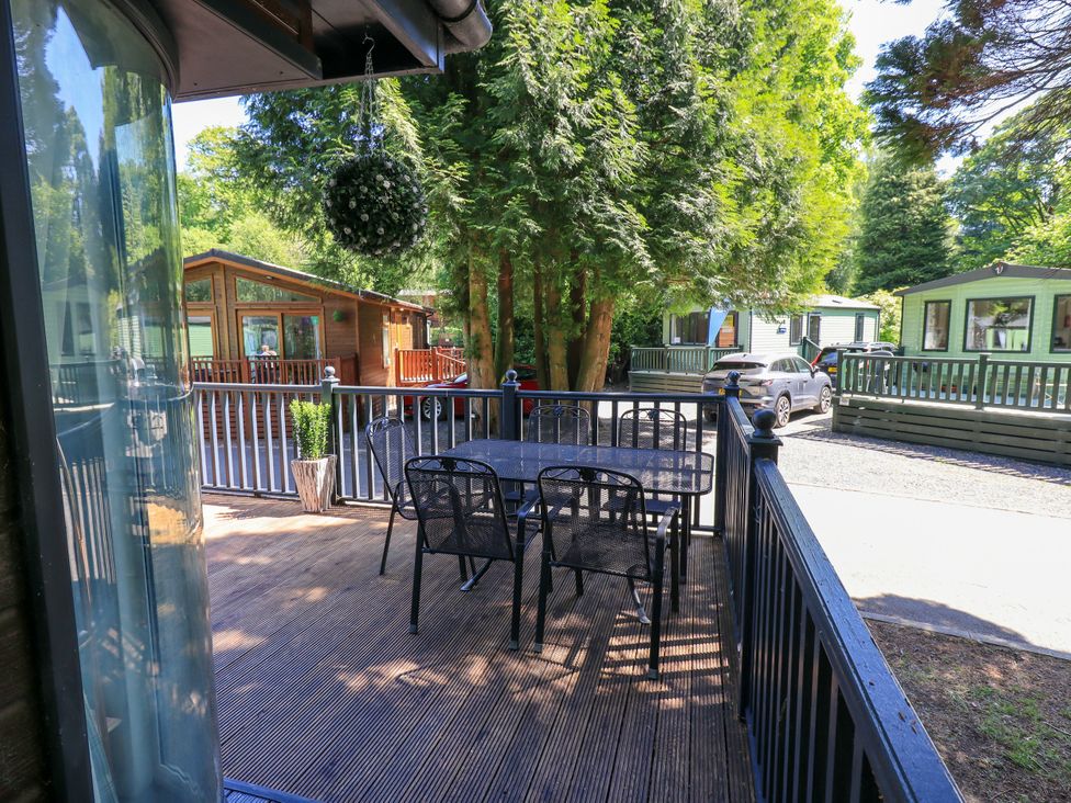 An outdoor deck with a table and chairs at Evermore Lodge, 48 Calgarth Park, White Cross Bay, Windermere