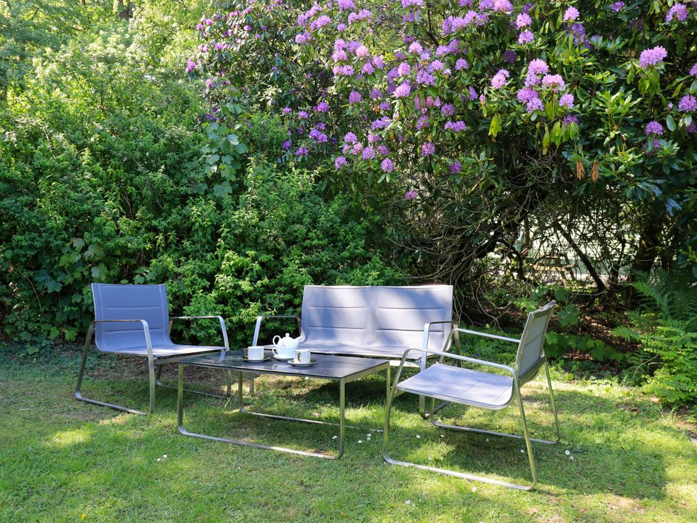 A garden with seating and a table at Evermore Lodge, 48 Calgarth Park, White Cross Bay, Windermere