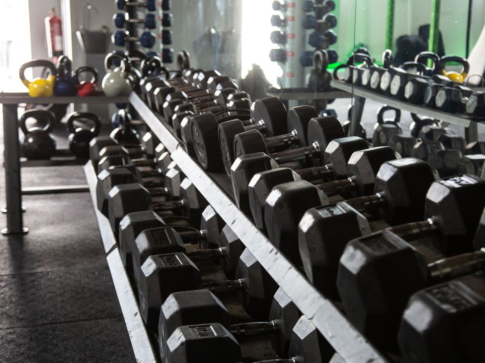 A gym with dumbbells and kettlebells at Evermore Lodge, 48 Calgarth Park, White Cross Bay, Windermere