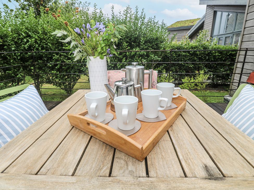An outdoor seating area with a tray of mugs and teapot at Una, Lodge 70 in Carbis Bay