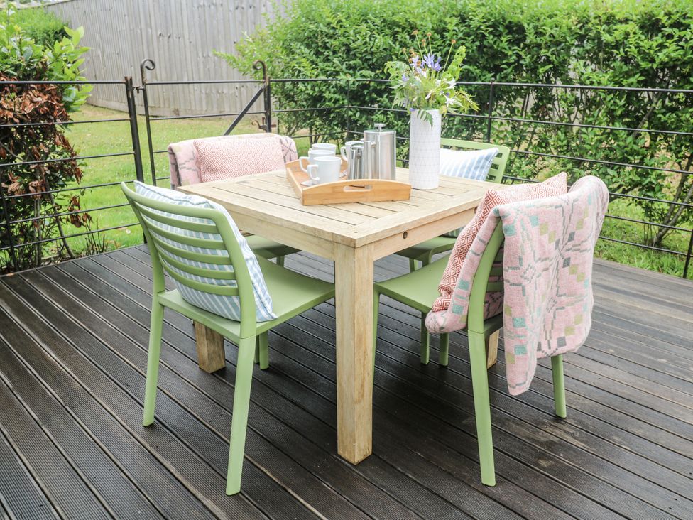 An outdoor seating area with a table and chairs at Una, Lodge 70, Carbis Bay