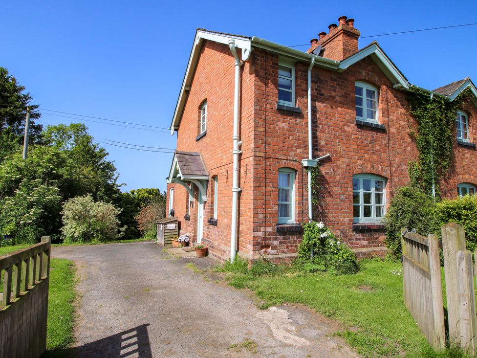 A brick house with a garden and pathway at Shepherd's Cottage in Eudon Burnell near Bridgnorth