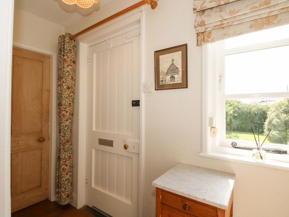A hallway with a door and side table at Shepherd's Cottage Eudon Burnell near Bridgnorth