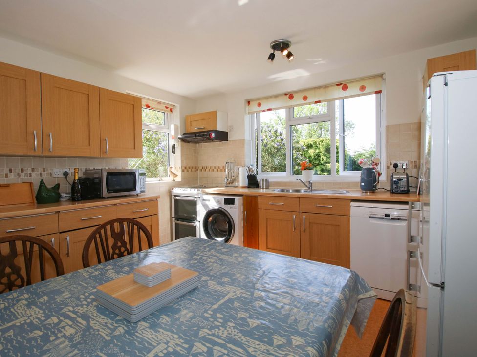 A kitchen with a dining table and appliances including a microwave and refrigerator at Shepherd's Cottage Eudon Burnell near Bridgnorth