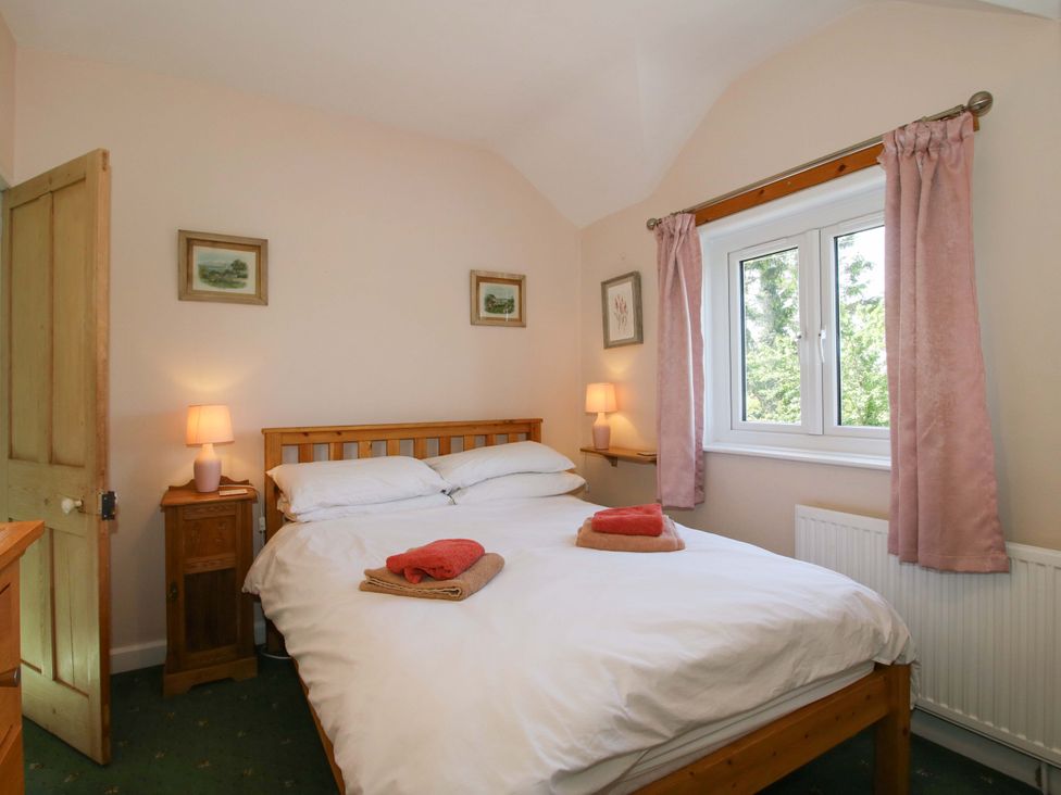A bedroom with a bed and bedside lamp at Shepherd's Cottage Eudon Burnell near Bridgnorth