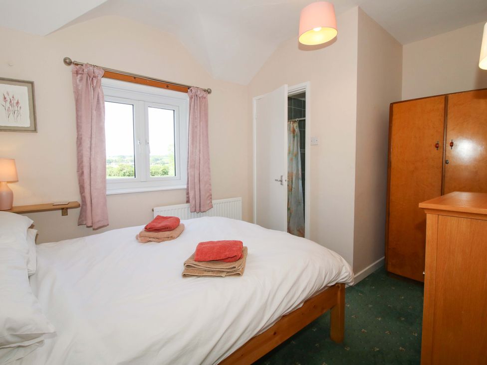 A bedroom with a bed and wardrobe at Shepherd's Cottage Eudon Burnell near Bridgnorth