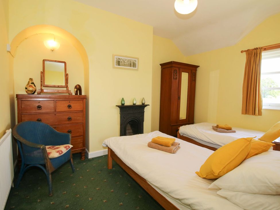 A bedroom with two beds and a wardrobe at Shepherd's Cottage Eudon Burnell near Bridgnorth