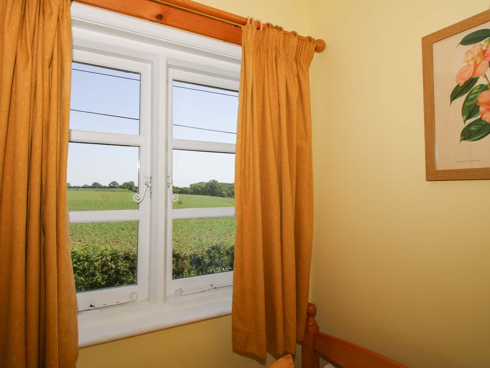 A window with curtains and a painting in a bedroom at Shepherd's Cottage Eudon Burnell near Bridgnorth