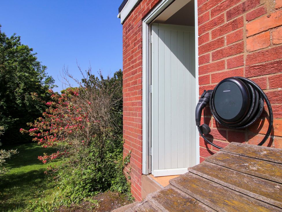 An electric car charging station next to a door at Shepherd's Cottage Eudon Burnell near Bridgnorth
