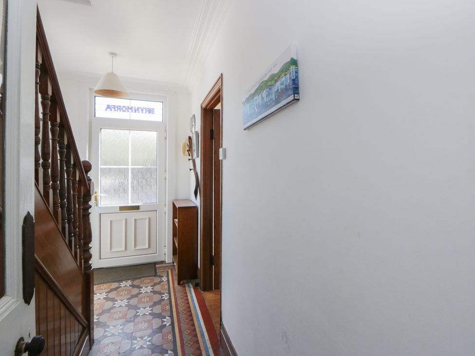 A hallway with a staircase and front door at Brynmorfa in Llandysul