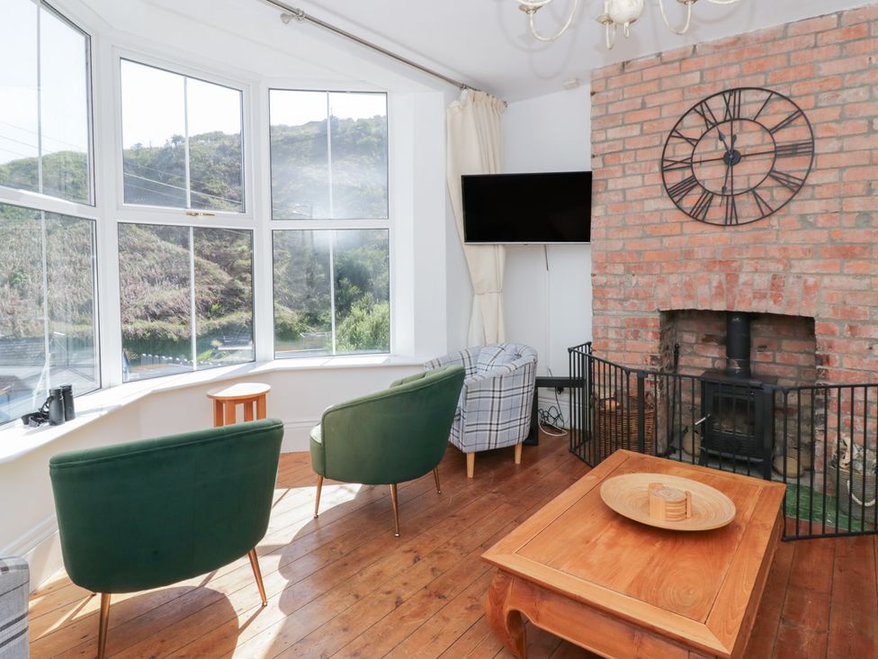 A living room with a fireplace and chairs at Brynmorfa in Llandysul
