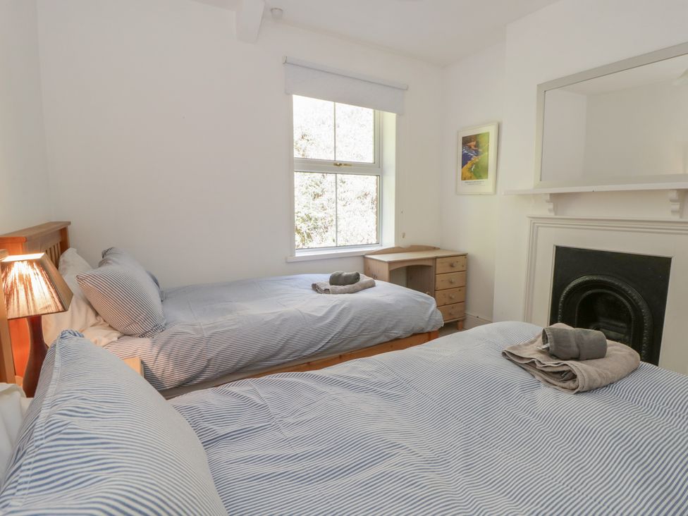 A bedroom with two beds and a dresser at Brynmorfa in Llandysul