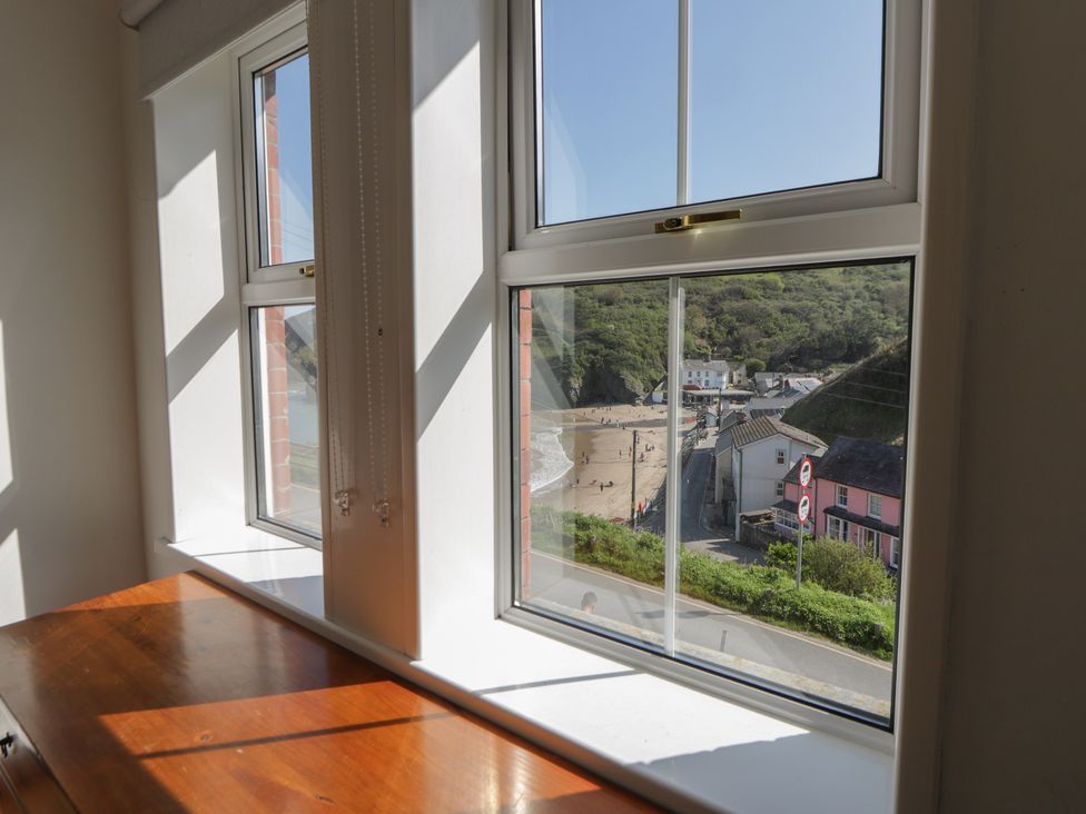 A view of houses and a beach from a window at Brynmorfa in Llandysul