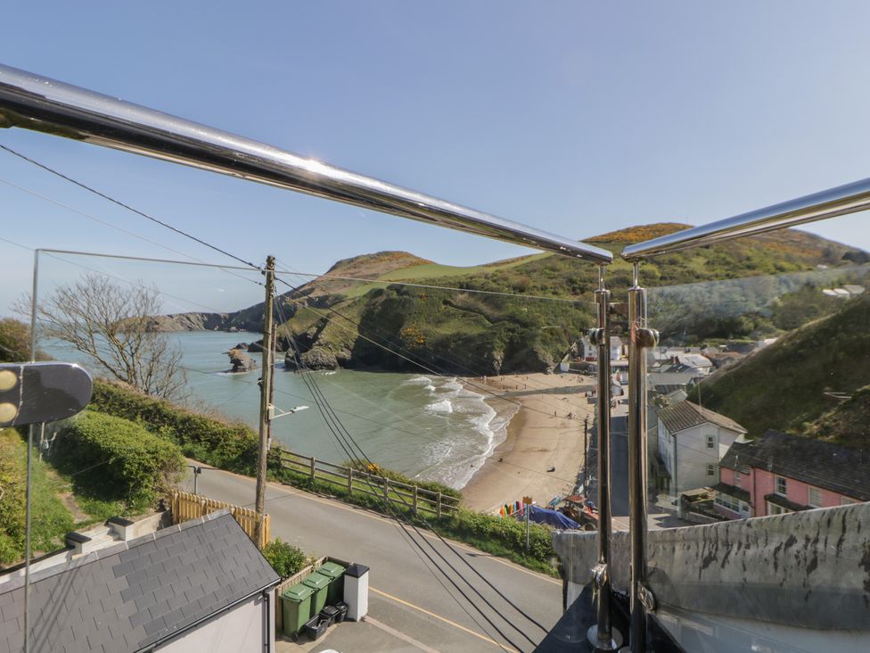 A view of a beach and hills from a balcony at Brynmorfa in Llandysul