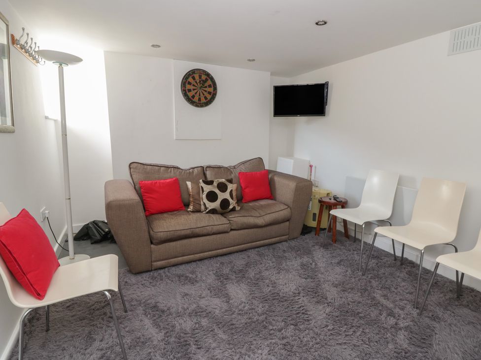 A snug with a sofa and dartboard at Brynmorfa in Llandysul