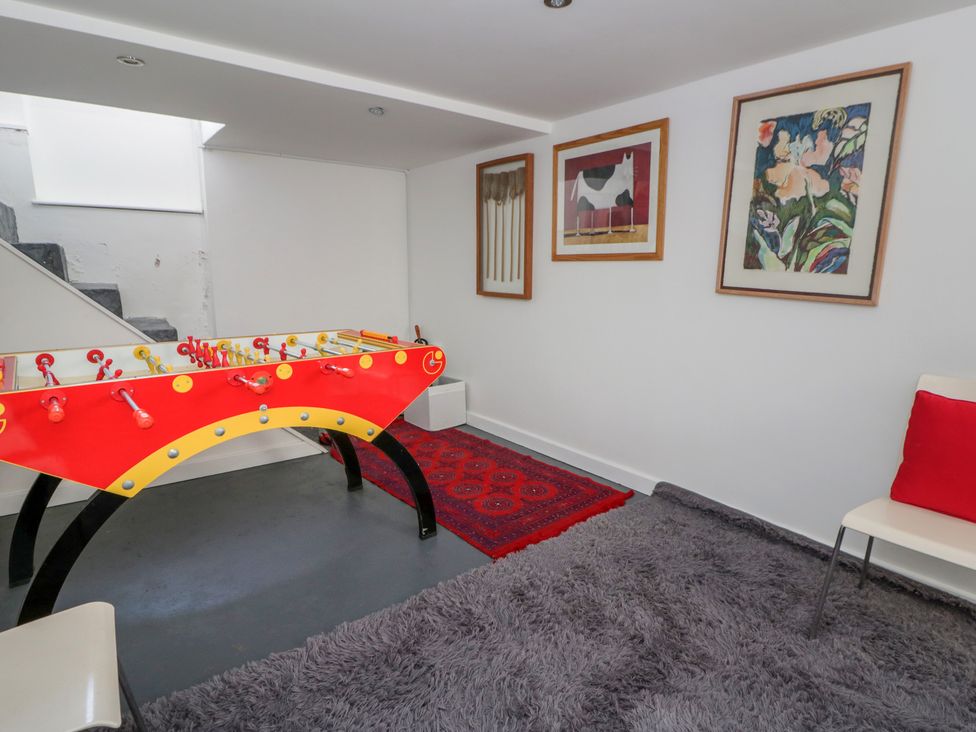A game room with a foosball table and paintings at Brynmorfa in Llandysul