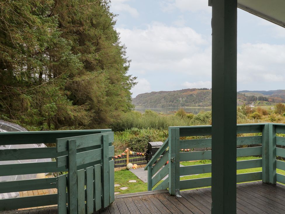 A view of a deck looking out at trees and water at Scarba in Oban