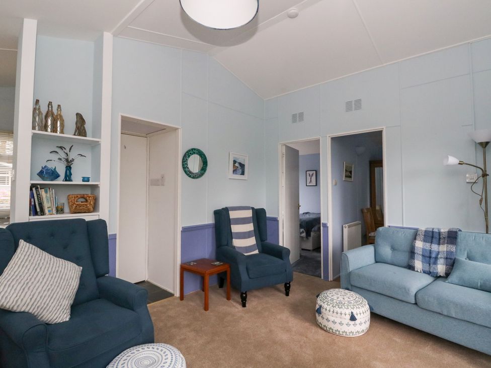 A living room with sofas and a bookshelf at Scarba in Oban