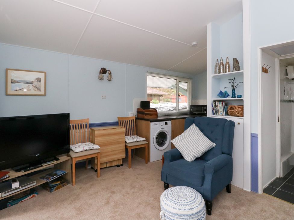A living room with a television and a washing machine at Scarba in Oban