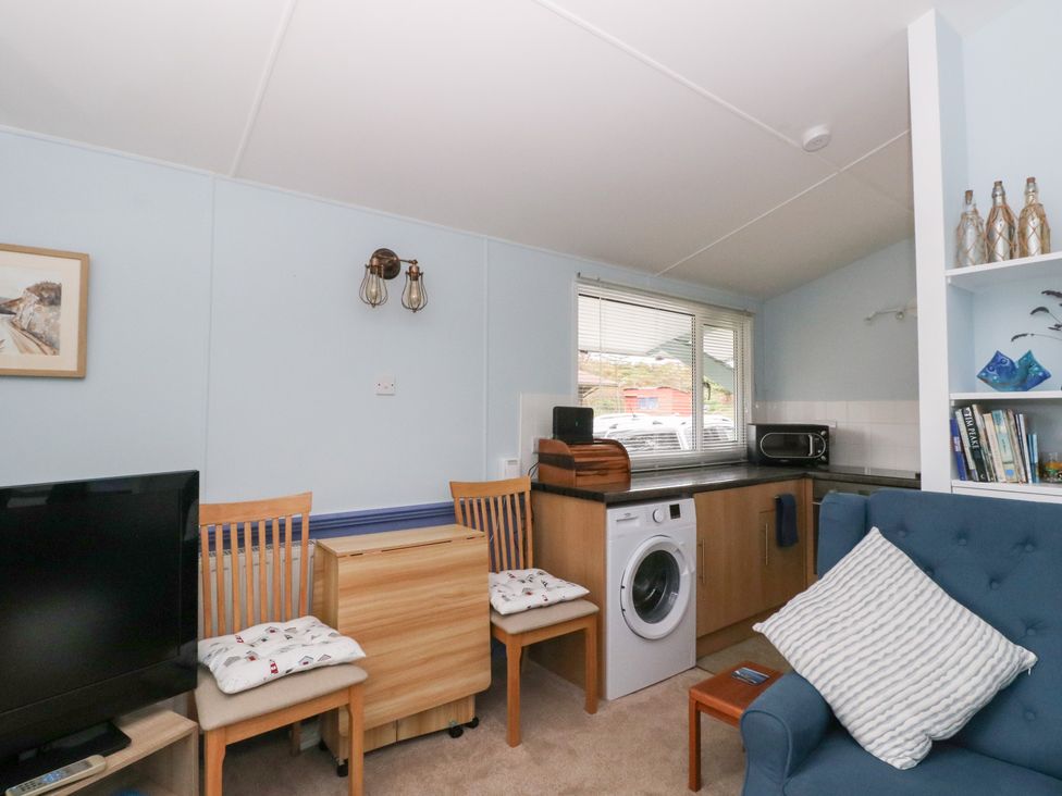 A living room with a washing machine and chairs at Scarba in Oban