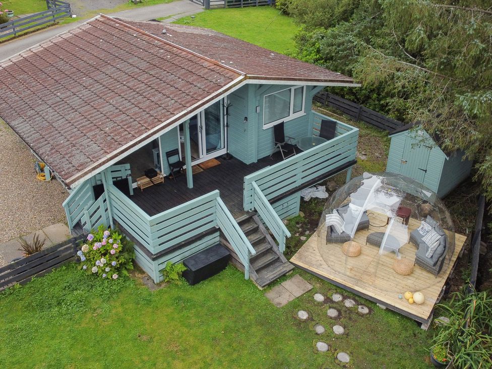 A house with a deck and outdoor furniture at Scarba Balvicar, Isle Of Seil