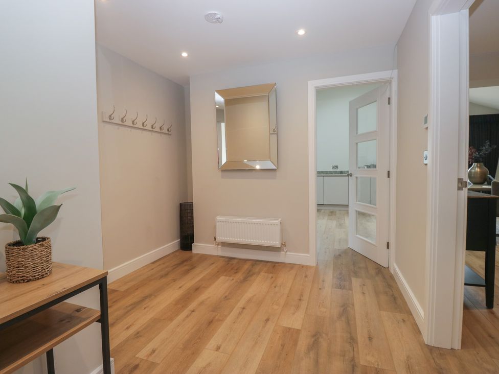A hallway with coat rack and mirror at Cross Winds in Clapham