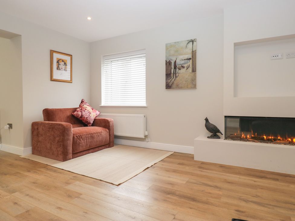 A living room with a sofa and a fireplace at Cross Winds in Clapham