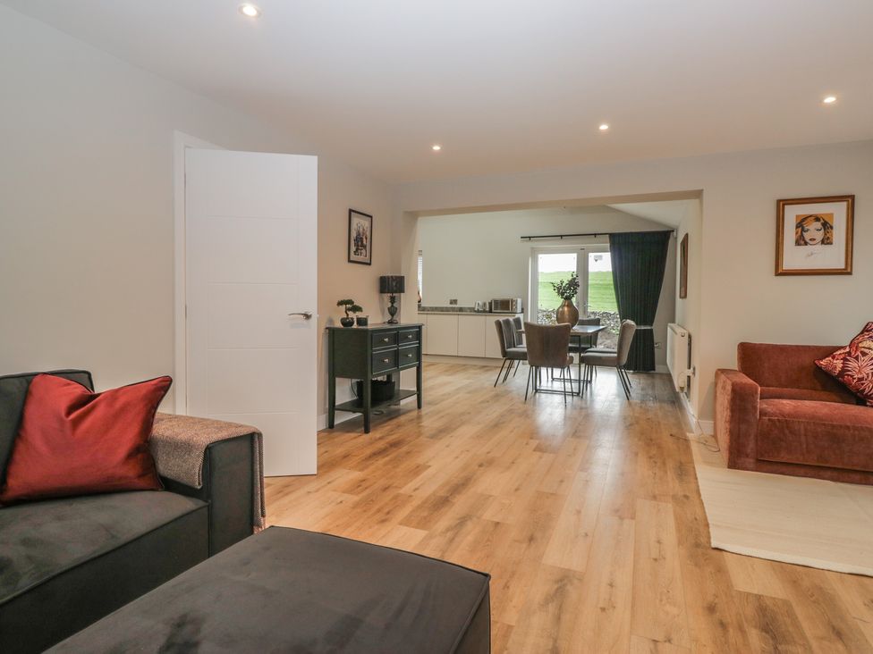 A living room with a sofa and dining area at Cross Winds in Clapham
