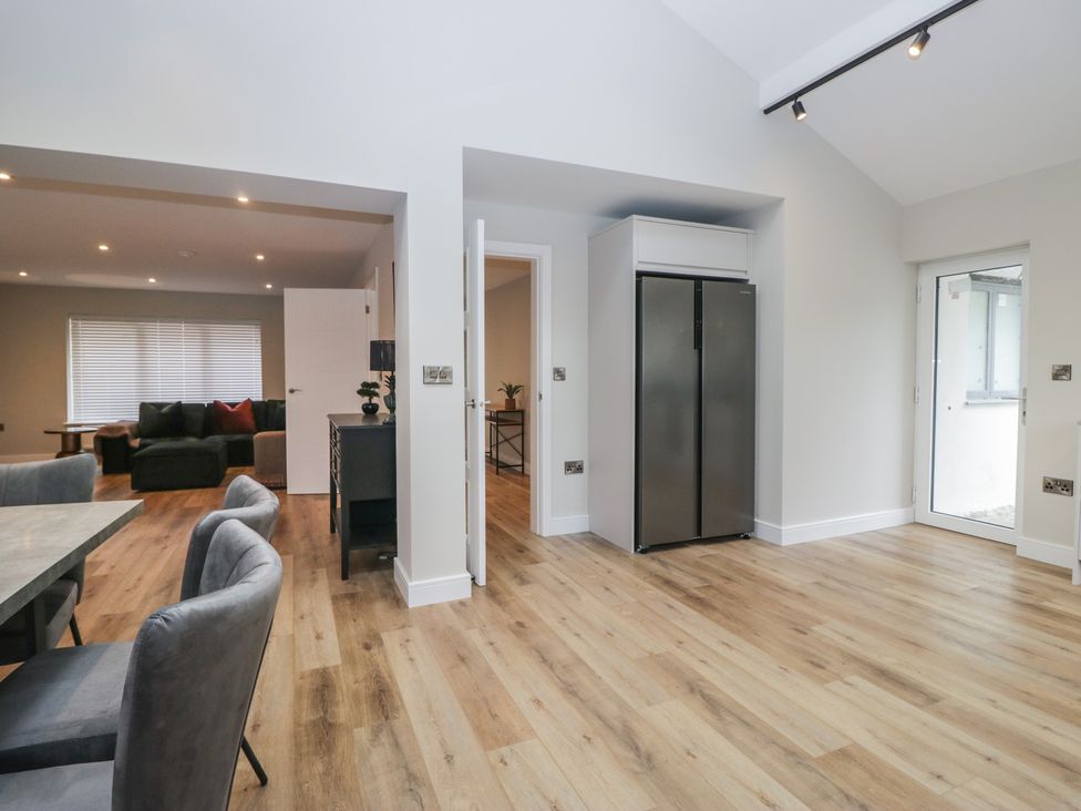 A kitchen with a refrigerator and dining area at Cross Winds in Clapham