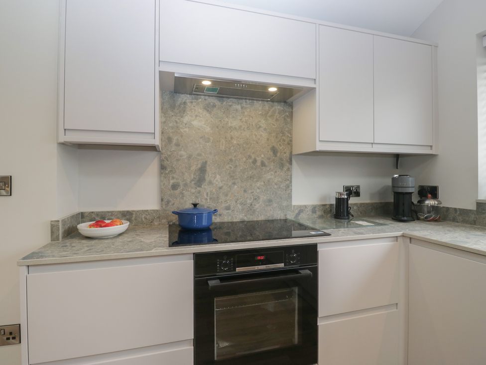 A kitchen with a stove, oven, and cabinets at Cross Winds in Clapham
