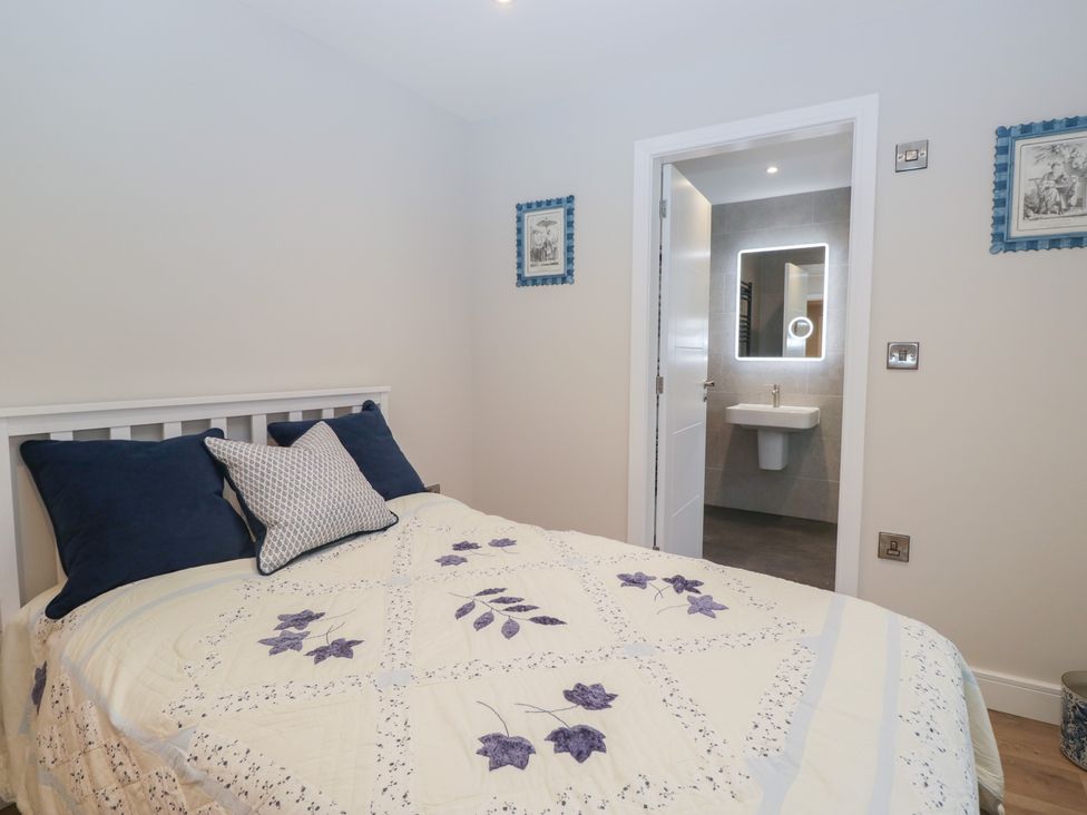 A bedroom with a bed and bathroom access at Cross Winds in Clapham