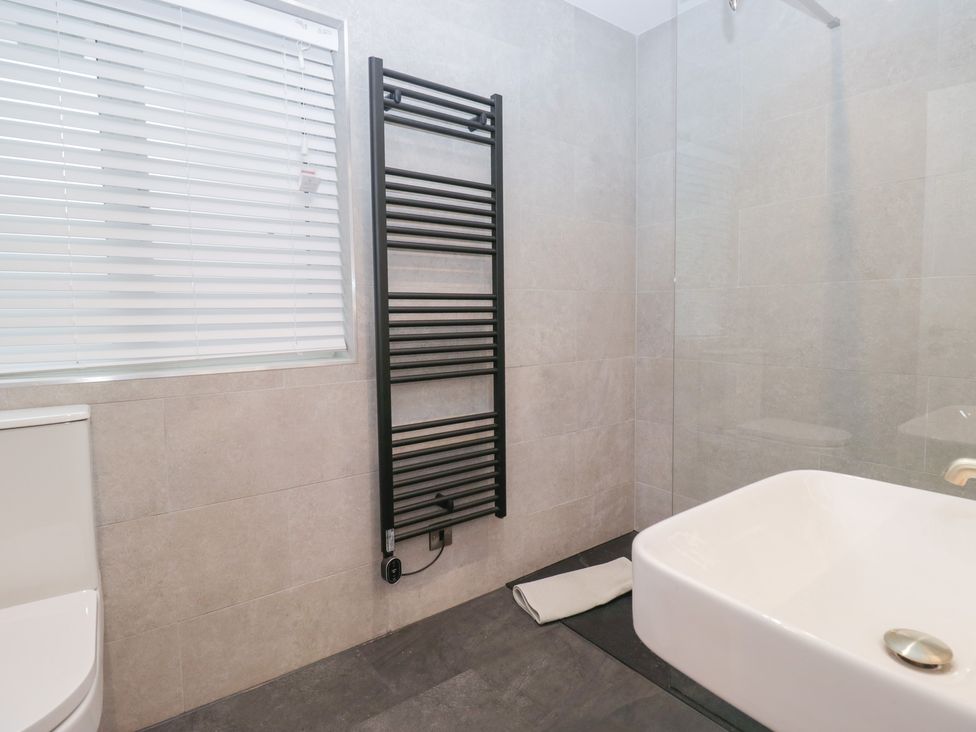 A bathroom featuring a sink, shower, and toilet at Cross Winds in Clapham