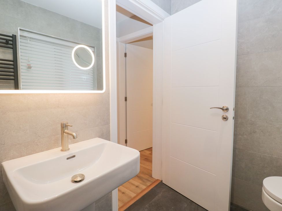 A bathroom with a sink and mirror at Cross Winds in Clapham