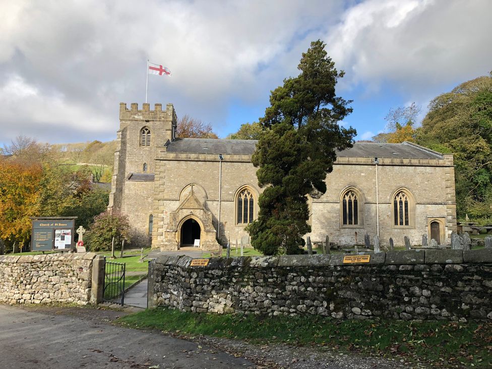 A church with a flag and trees at Cross Winds in Clapham