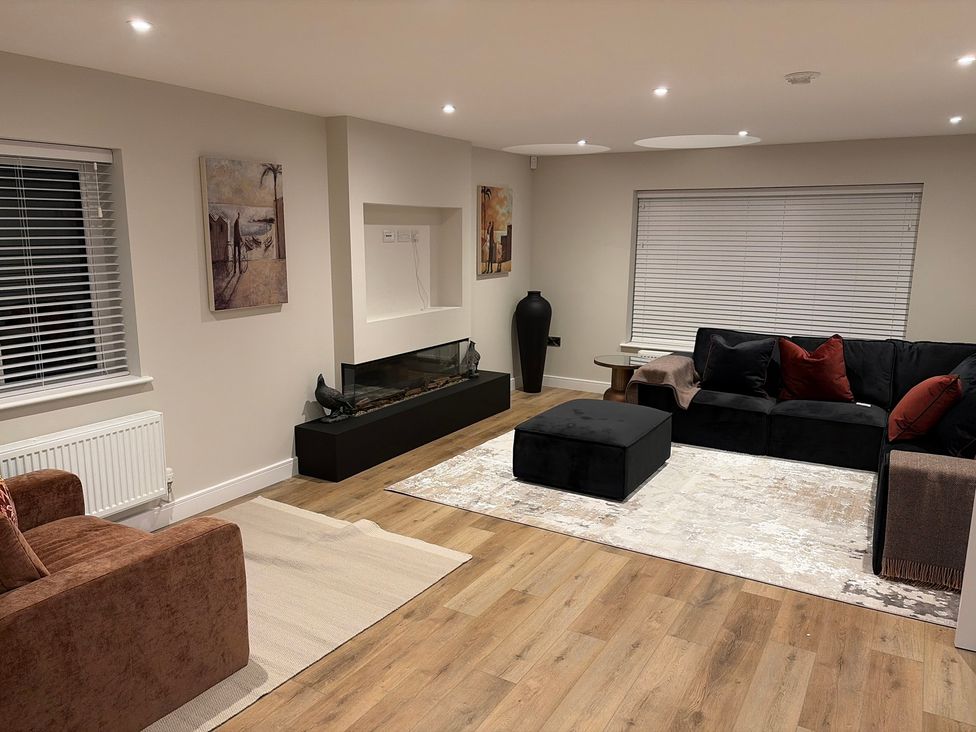 A living room with a sofa and fireplace at Cross Winds in Clapham