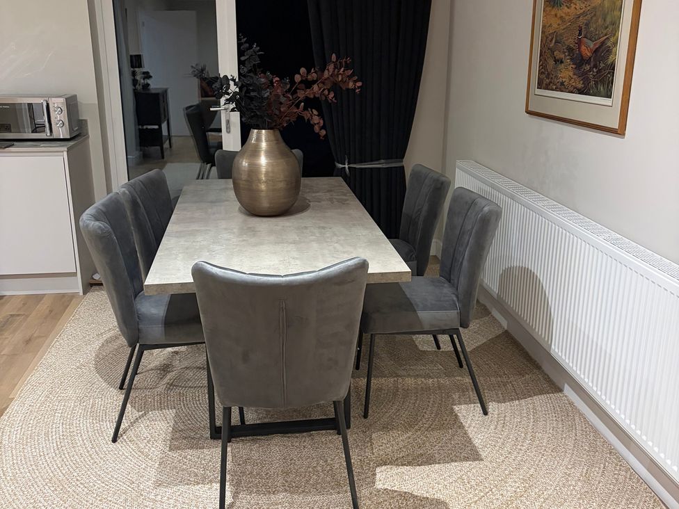 A dining room with a table and chairs at Cross Winds in Clapham