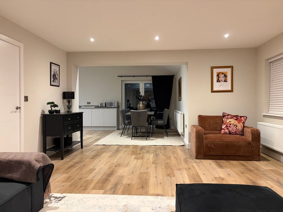 A living room with a sofa and an armchair at Cross Winds in Clapham