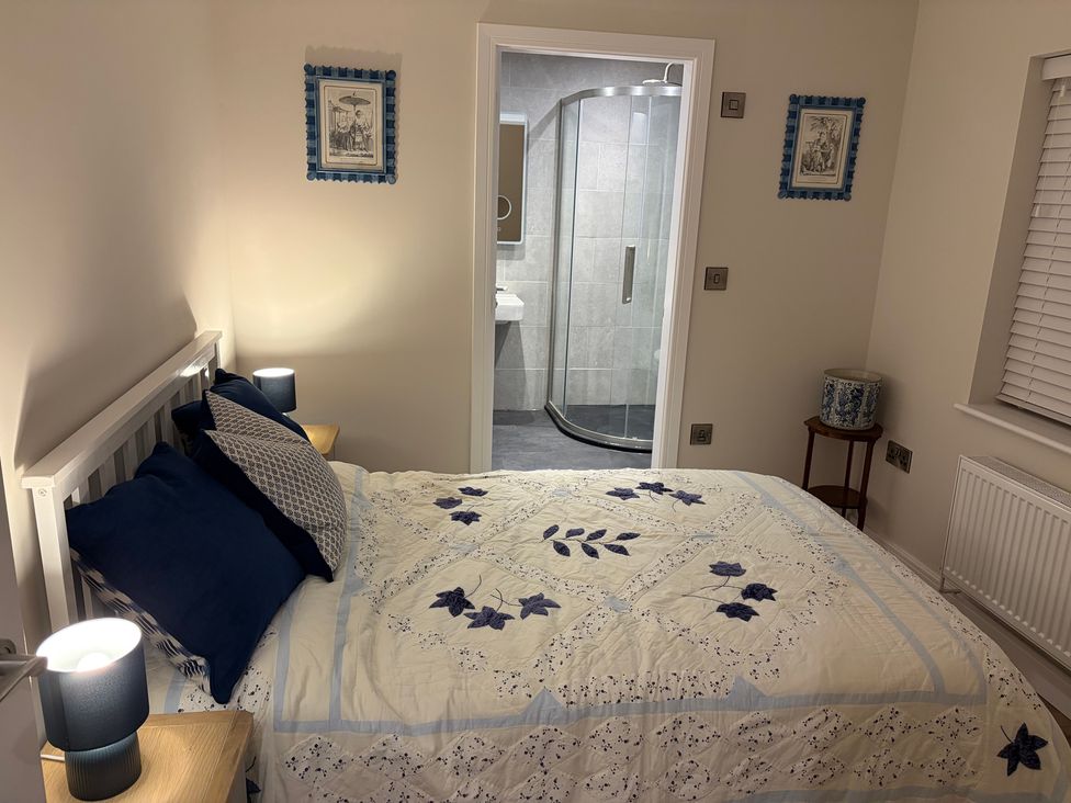 A bedroom with a bed and en-suite bathroom at Cross Winds in Clapham