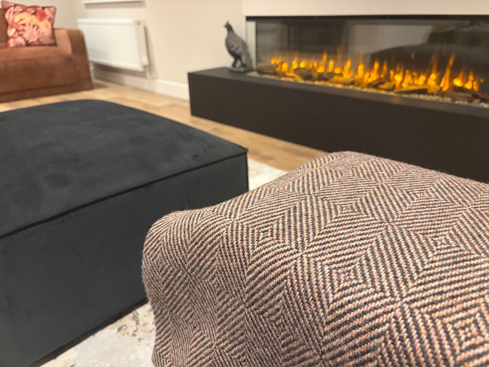 A living room with a sofa and fireplace at Cross Winds in Clapham