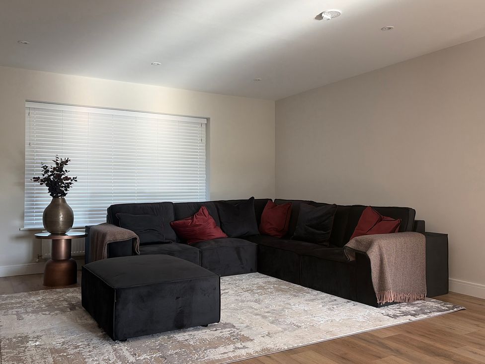 A living room with a sofa and table at Cross Winds in Clapham