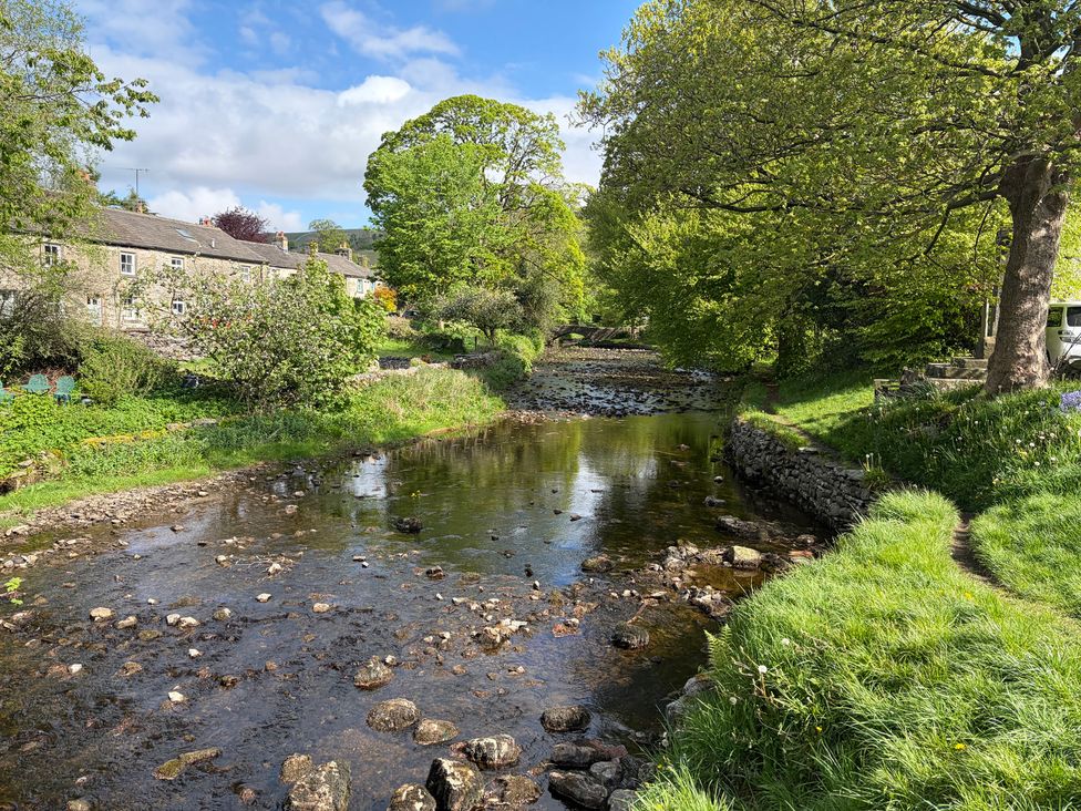 A river with stones and trees near houses at Cross Winds Clapham