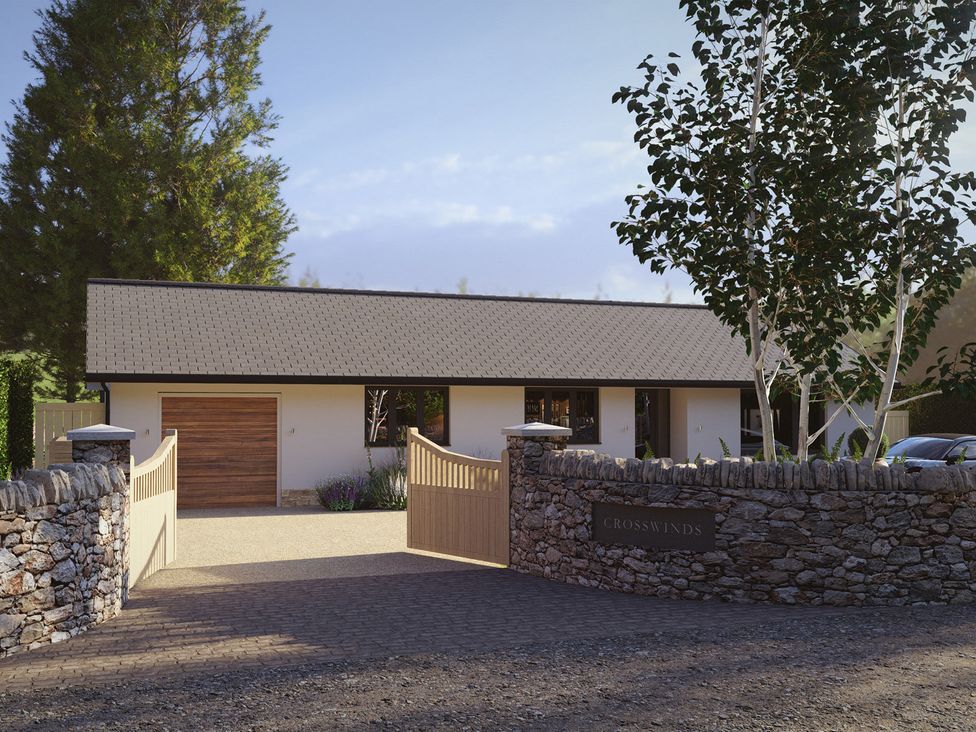 A house with a gated entrance and stone wall at Cross Winds in Clapham