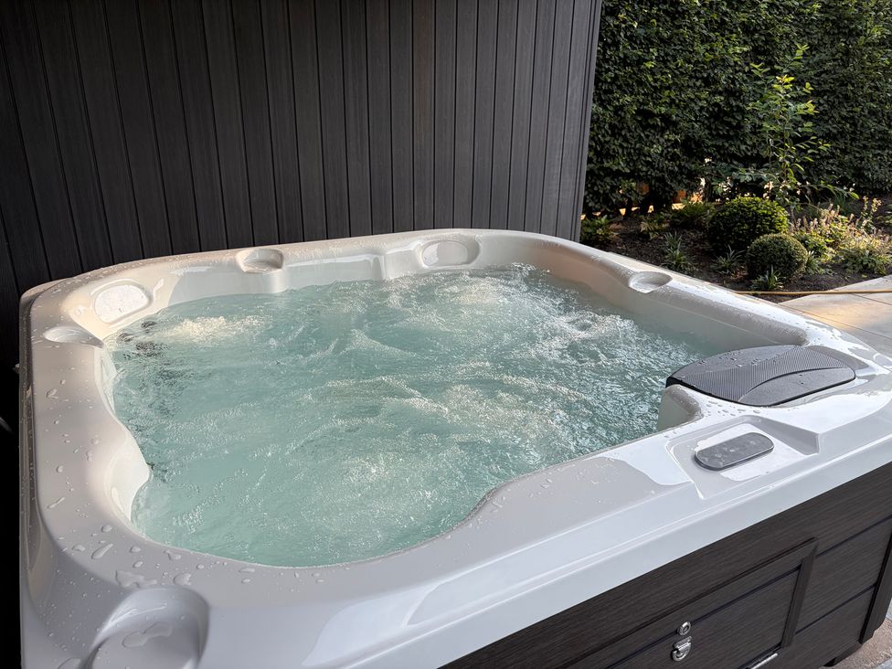 A hot tub with water in it in an outdoor area at Cross Winds in Clapham
