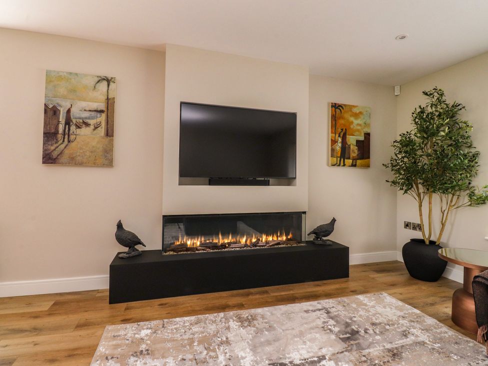 A living room with a television and fireplace at Cross Winds in Clapham
