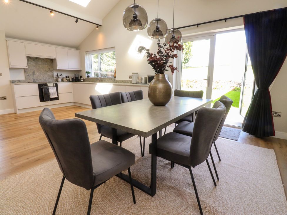 A dining room with a table and chairs at Cross Winds in Clapham