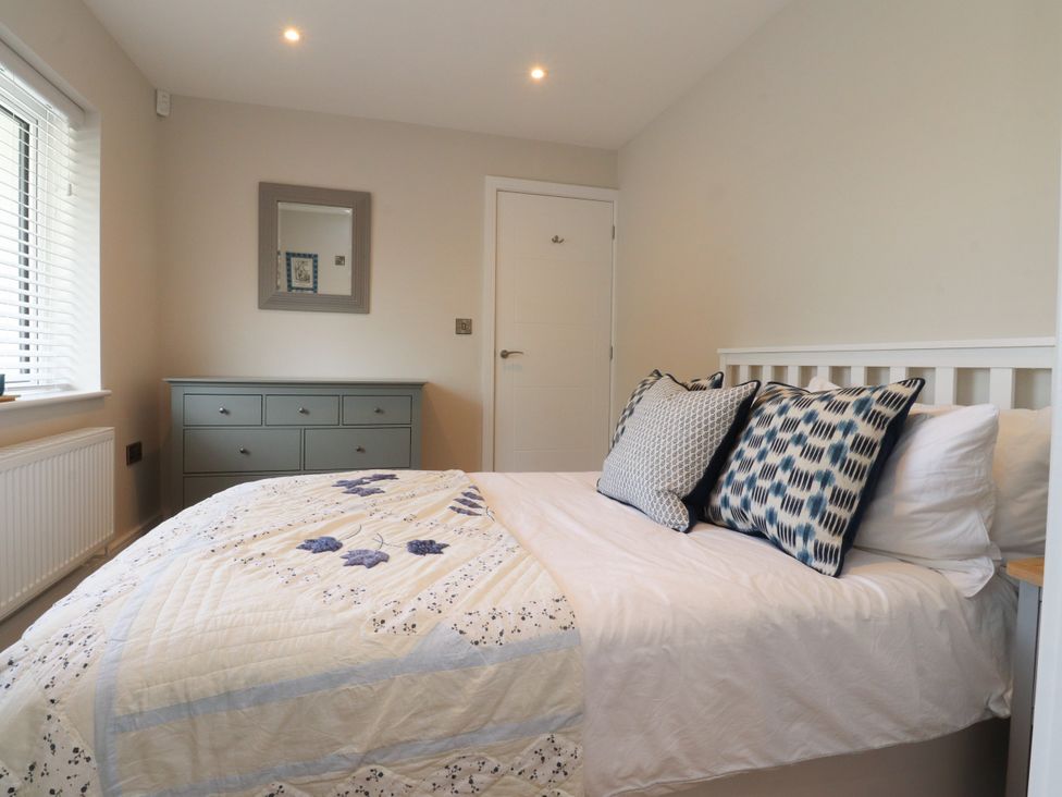 A bedroom with a bed and dresser at Cross Winds in Clapham
