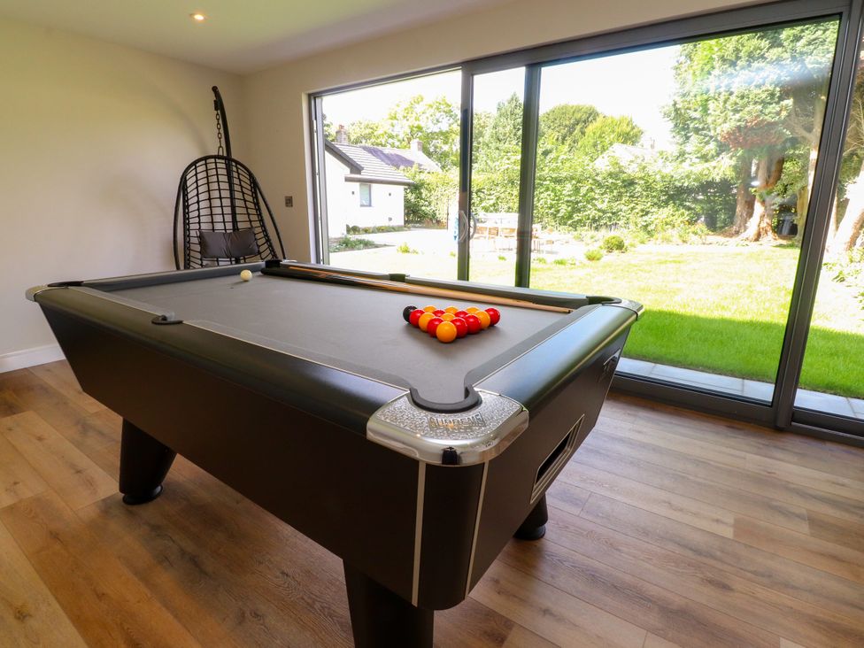 A games room with a pool table and a view of the garden at Cross Winds in Clapham