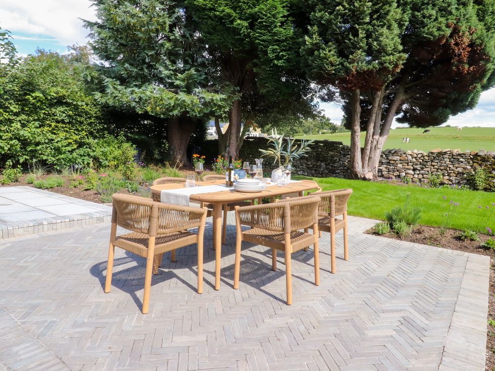 A garden with a dining table and chairs at Cross Winds in Clapham
