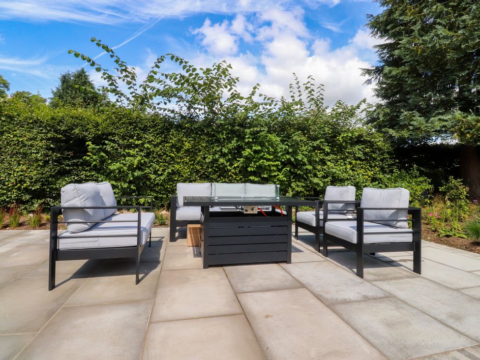 A garden with outdoor seating and a glass table at Cross Winds in Clapham