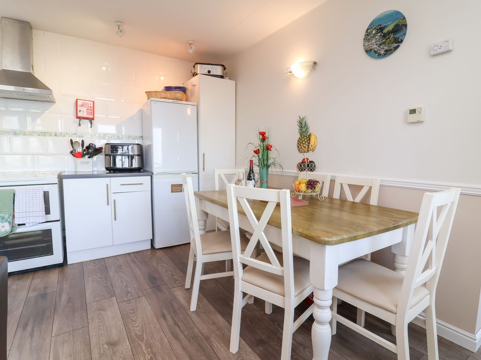 A kitchen with a dining table and chairs at Castle View Lodge in Ilfracombe